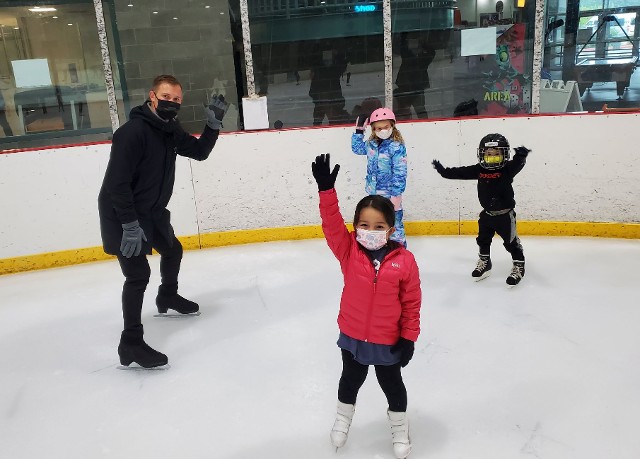 Instructor teaching students learning to skate